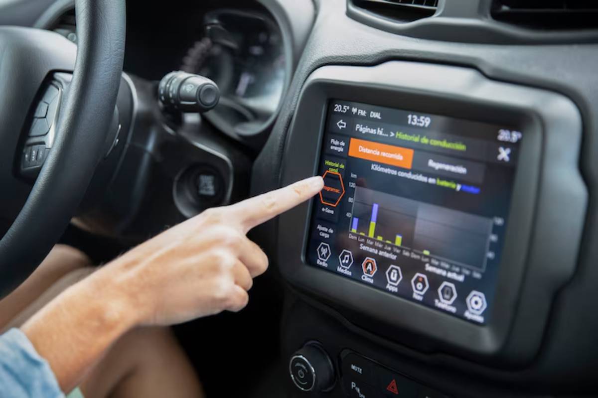 A driver touches a touchscreen displaying driving history and statistics in a modern car's dashboard.