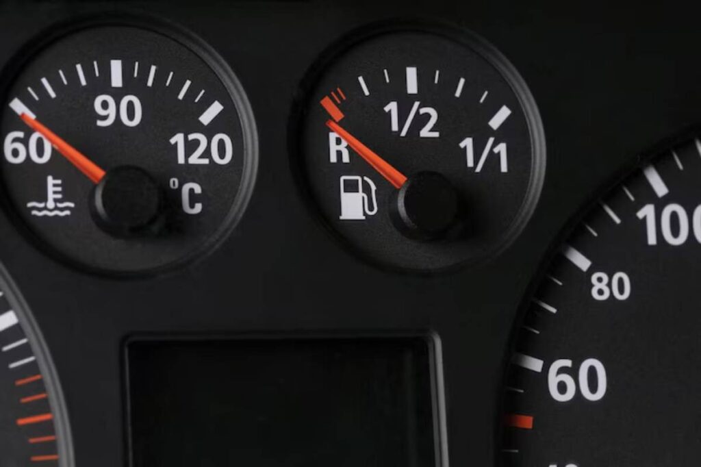 Close-up of a vehicle's dashboard showing the temperature gauge at 60°C and the fuel gauge half full.