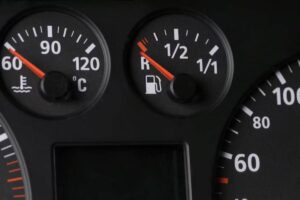 Close-up of a vehicle's dashboard showing the temperature gauge at 60°C and the fuel gauge half full.