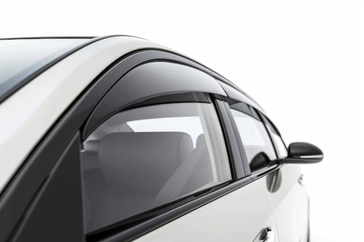 Close-up of a white car's window with sleek black trim, showcasing its modern design and spacious interior visible through the glass.