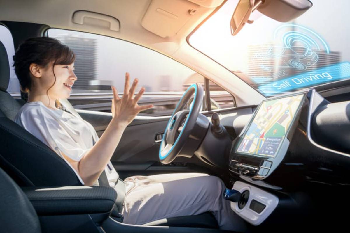 A person gestures excitedly inside a self-driving car, with a high-tech dashboard displaying navigation and driving status.